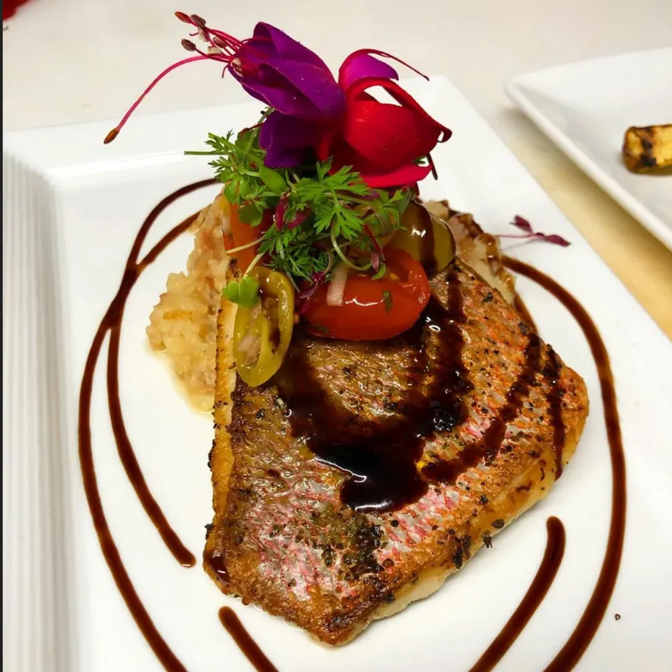 Seared fish filet with roasted tomato and reduction